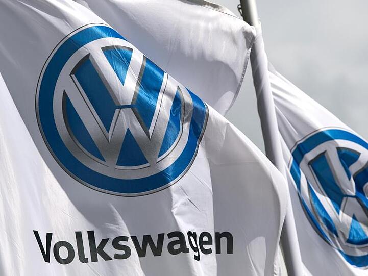 Flaggen mit dem VW-Logo vor einem Werk des Autokonzerns.