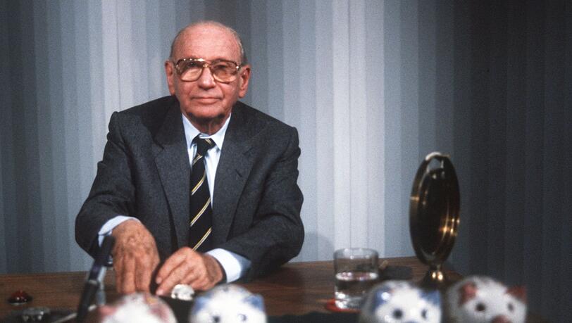"Welches Schweinderl hätten Sie denn gern?": Quizmaster Robert Lembke 1985 mit den berühmten "Was bin ich?"-Sparschweinen.