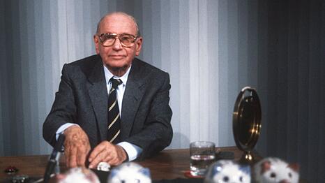 "Welches Schweinderl hätten Sie denn gern?": Quizmaster Robert Lembke 1985 mit den berühmten "Was bin ich?"-Sparschweinen.