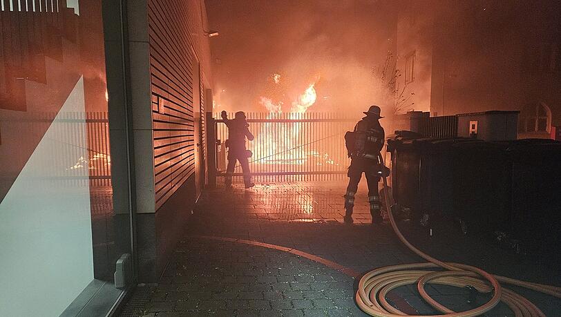 Die Münchner Feuerwehr löscht in der Leopoldstraße mehrere Rollwagen mit Kartonagen, durch die große Hitze wird das angrenzende Bürohaus beschädigt.