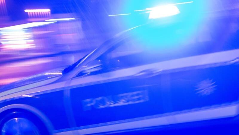 Ein Polizeiauto fährt im Einsatz mit Blaulicht über eine Straße. (Symbolbild)