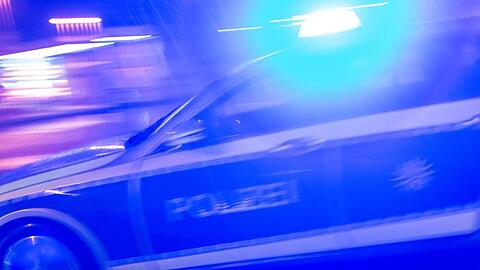 Ein Polizeiauto fährt im Einsatz mit Blaulicht über eine Straße. (Symbolbild)