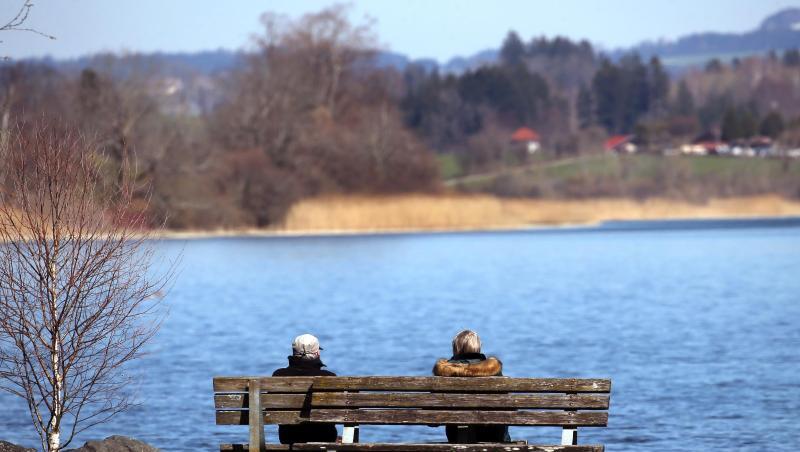 Ausflügler genießen auf einer Bank am Niedersonthofener See den Sonnenschein. Foto: Karl-Josef Hildenbrand/dpa/Archivbild