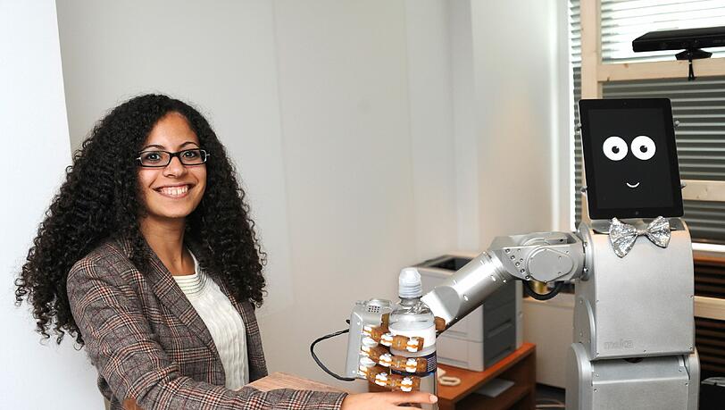 Roboter James bringt das Wasser: James versteht bisher nur Englisch. Aber das gut. Wenn Wissenschaftlerin Nadine bei ihm etwas zu Trinken bestellt, reicht er ihr flugs eine Flasche Wasser. Auch die Besucher am Tag der offenen Tür können sich vom Barmann-Roboter bedienen lassen. Er kann selbständig mit Menschen kommunizieren. Und er kann mit Hilfe seines Tablet-„Gesichts“ zwinkern und lächeln. James ist ein konkreter Ausblick auf die Zukunft – etwa als Haushaltshelfer für alte Menschen. Roboter James bringt das Wasser: James versteht bisher nur Englisch. Aber das gut. Wenn Wissenschaftlerin Nadine bei ihm etwas zu Trinken bestellt, reicht er ihr flugs eine Flasche Wasser. Auch die Besucher am Tag der offenen Tür können sich vom Barmann-Roboter bedienen lassen. Er kann selbständig mit Menschen kommunizieren. Und er kann mit Hilfe seines Tablet-„Gesichts“ zwinkern und lächeln. James ist ein konkreter Ausblick auf die Zukunft – etwa als Haushaltshelfer für alte Menschen.