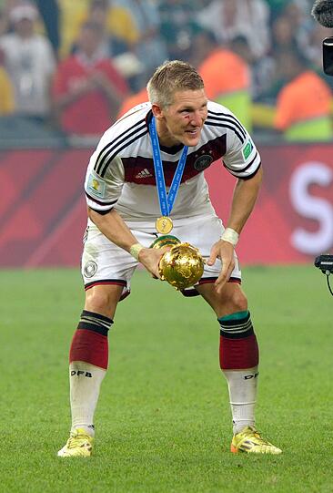 Ein abgekämpfter Bastian Schweinsteiger mit dem WM-Pokal.