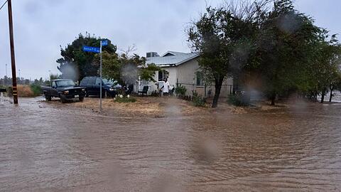 Ein Anwohner prüft während eines Regengusses in Palmdale die Überschwemmungen rund um sein Haus.
