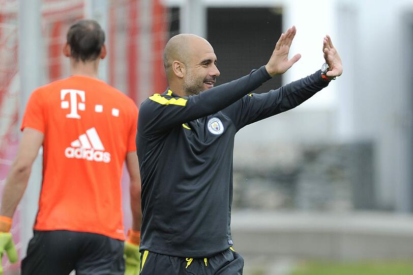 Freudestrahlend begrüßt Pep Guardiola die Bayern-Fans an der Säbener Straße.