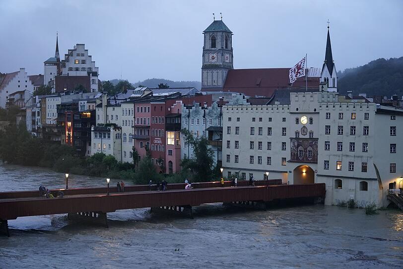 Hochwasser am Inn: Schaulustige beobachten am Abend von einer Brücke aus den Wasserstand.