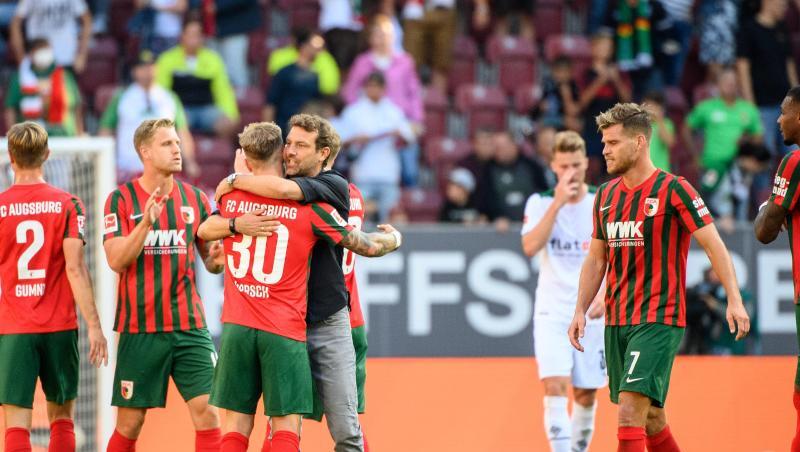 Trainer Markus Weinzierl von Augsburg (M) feiert den Sieg mit seiner Mannschaft.
