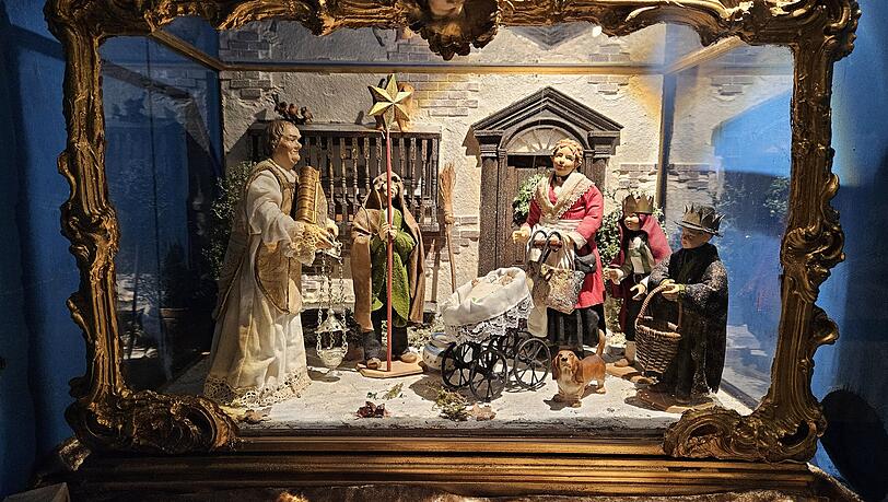 Diese Kastenkrippe mit hübschen goldenem Schnörkelrahmen zeigt eine Sternsinger-Szene.