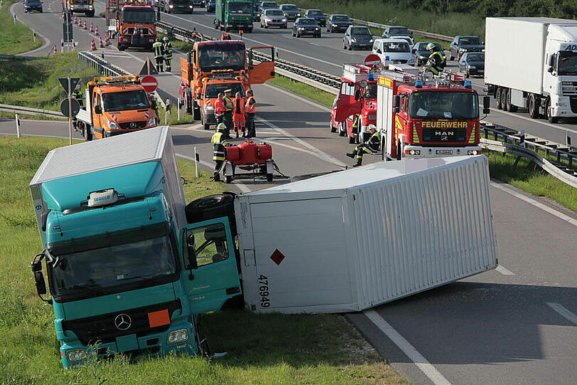Vermutlich weil er zu schnell auf die Autobahn fährt, kommt ein Laster in der Kurve von der Fahrbahn ab und fährt in die Leitplanke. Sein Hänger kippt um.