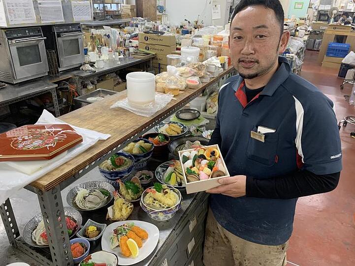 Hält sich auch ohne Kühlschrank jahrelang: Fabrikleiter Hiroaki zeigt eine Bento-Lunchbox mit Reis, Gemüse und Meeresfrüchten.