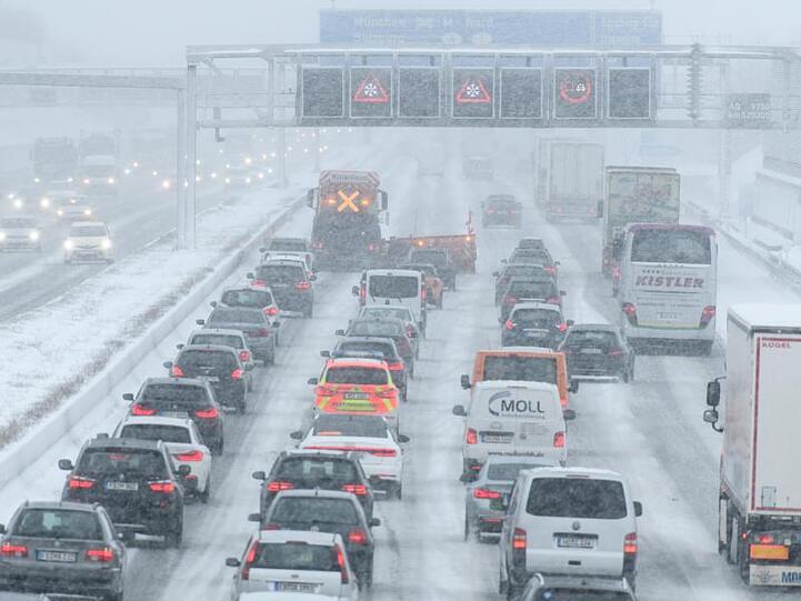 Hinter einem Räumfahrzeug staut sich auf der Autobahn 9 im Schneetreiben der Verkehr.