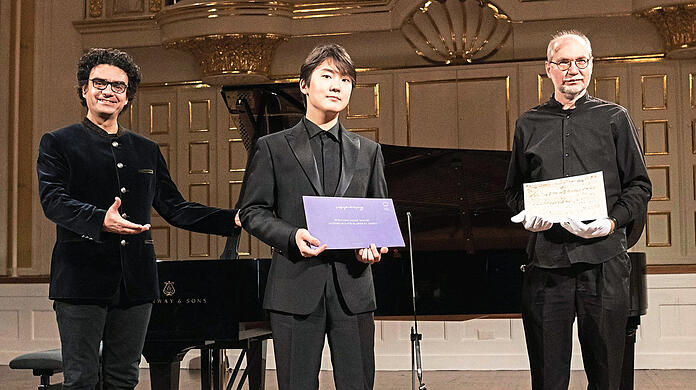 Rolando Villazon), der Intendant der Mozartwoche, mit dem koreanischen Pianisten Seong-Jin Cho und Ulrich Leisinger, dem wissenschaftlicher Leiter der Stiftung Mozarteum Salzburg im Großen Saal des Mozarteums in Salzburg, mit dem Manuskript des Stücks.