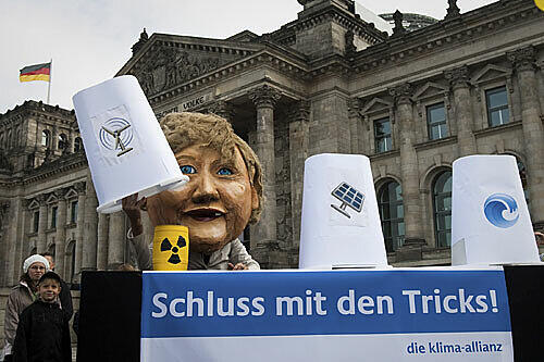 Anti-Atomkraft-Aktivisten werfen Bundeskanzlerin Angela Merkel bei der Energiepolitik Taschenspielertricks vor.