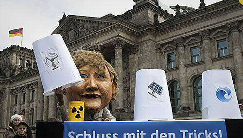 Anti-Atomkraft-Aktivisten werfen Bundeskanzlerin Angela Merkel bei der Energiepolitik Taschenspielertricks vor. Anti-Atomkraft-Aktivisten werfen Bundeskanzlerin Angela Merkel bei der Energiepolitik Taschenspielertricks vor.