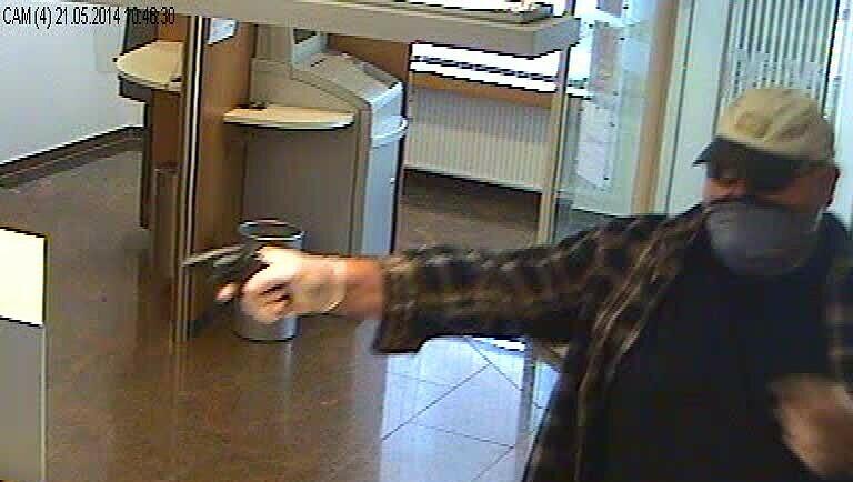 Er streckt seinen Revolver den Angestellten entgegen. Er streckt seinen Revolver den Angestellten entgegen.