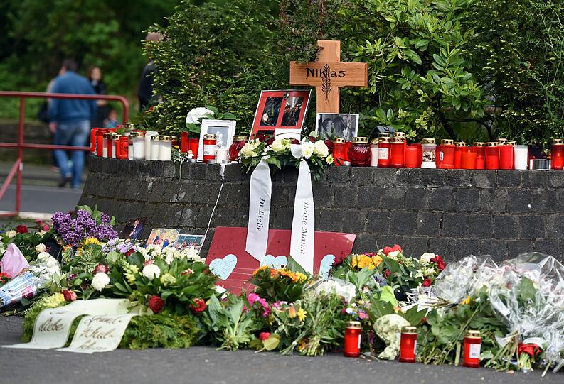Blumen und Kerzen stehen vor dem Kreuz an der Stelle, an der der später verstobene Niklas P. von bisher unbekannten Schlägern attackiert wurde.