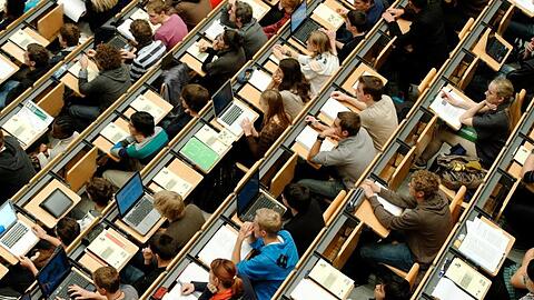 Studenten sitzen in einem großen Hörsaal der Technischen Universität (TUM). Foto: Peter Kneffel/Archivbild