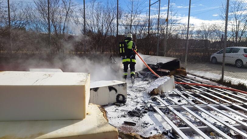Ein Feuerwehrmann beim Löschen der Matte.