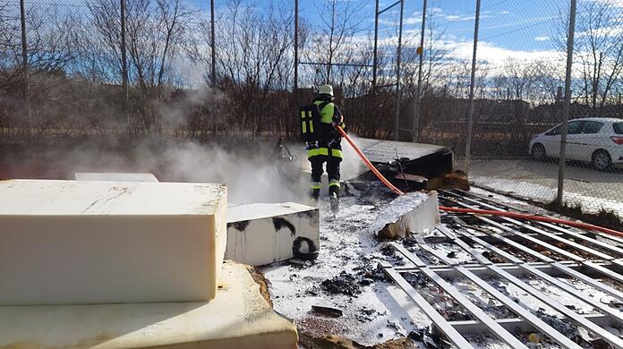 Ein Feuerwehrmann beim Löschen der Matte.