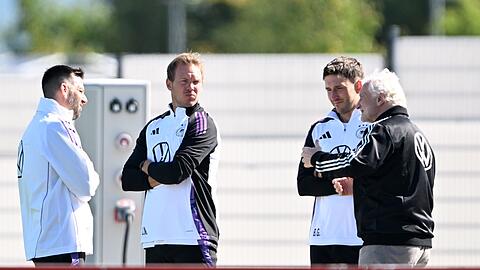Sportdirektor Rudi Völler (r.) spricht mit Bundestrainer Julian Nagelsmann (2.v.l.) vor dem Training.