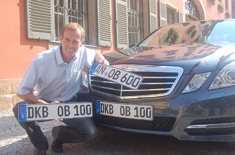 Der Dinkelsbühler OB Christoph Hammer hält in Dinkelsbühl sein neues Kennzeichen mit alter Ortsabkürzung &bdquo;DKB-OB 100&ldquo; in den Händen.