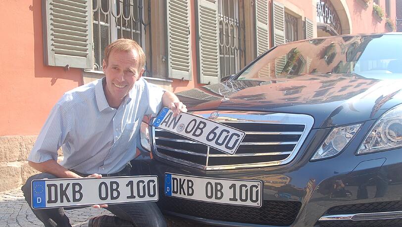Der Dinkelsbühler OB Christoph Hammer hält in Dinkelsbühl sein neues Kennzeichen mit alter Ortsabkürzung &bdquo;DKB-OB 100&ldquo; in den Händen.