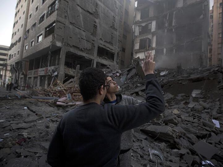 Palästinenser vor einem zerstörten Wohngebäude in Gaza-Stadt.