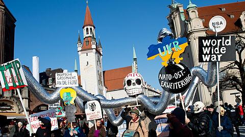 Zahlreiche Menschen mit Plakaten und Bannern und einer symbolischen "NATO-Krake" protestieren am 07.02.2015 in München gegen die 51. Münchner Sicherheitskonferenz.