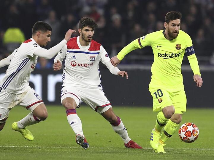 Lionel Messi (r) behauptet den Ball gegen Houssem Aouar (l) und Martin Terrier von Olympique Lyon.