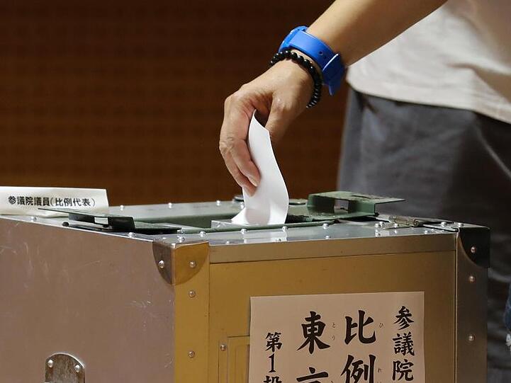 Ein Wähler wirft in einem Wahllokal in Tokio einen Stimmzettel in eine Wahlurne. In Japan hat die Oberhauswahl stattgefunden.