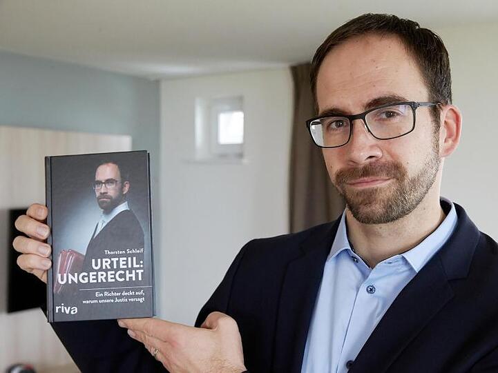 Amtsrichter Thorsten Schleif zeigt sein Buch mit dem Titel "Urteil ungerecht".
