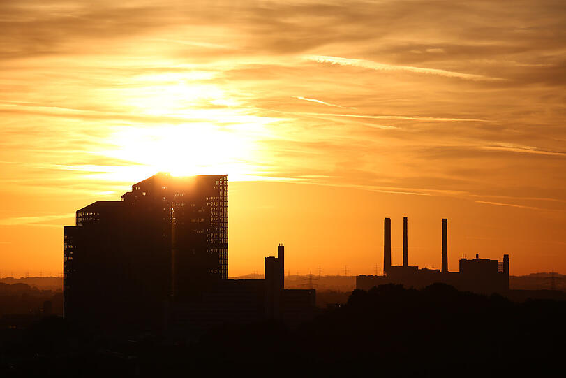 Die Sonne glüht durch die Highlight Towers, rechts das Heizwerk Nord.