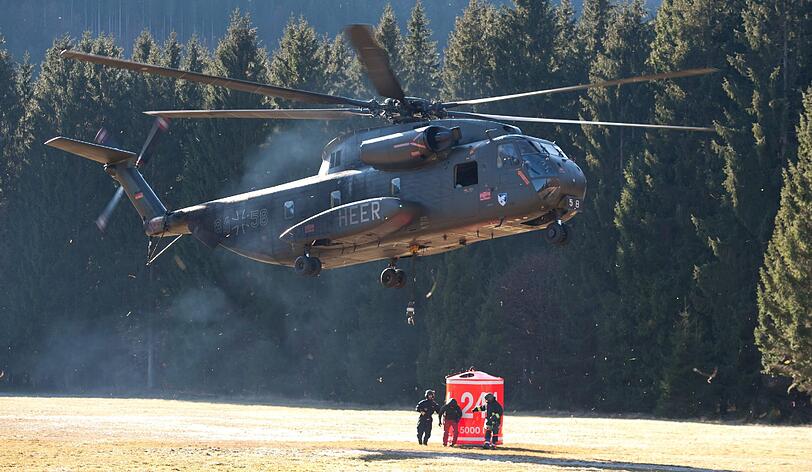 Um die Brände am Schwarzberg in Lenggries zu löschen, befestigt die Feuerwehr Wassertanks an den Hubschraubern....