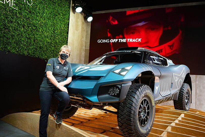 Rallyefahrerin Jutta Kleinschmidt vor ihrem Wagen.
