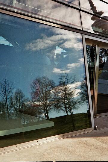 Die Glasfassade der BMW-Welt spiegelt die Welt drumherum.