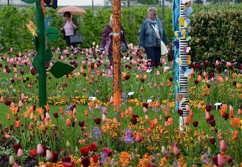 Die ersten Besucher laufen am 26.04.2014 in Gießen (Hessen) über das Gelände der Landesgartenschau. Während der 163 Tage des Blumenfestes stehen mehr als 2000 Veranstaltungen auf dem Programm, darunter Pflanzenausstellungen, Konzerte, Kunst, Comedy, Sportaktionen oder Angebote für Kinder. Bis zum 5. Oktober erwartet die Stadt 700 000 Besucher.