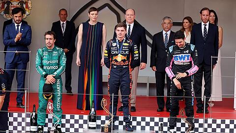 Monaco-Sieger Max Verstappen (M) steht zwischen dem Zweitplatzierten Fernando Alonso (l) und Esteban Ocon auf dem Siegerpodium.