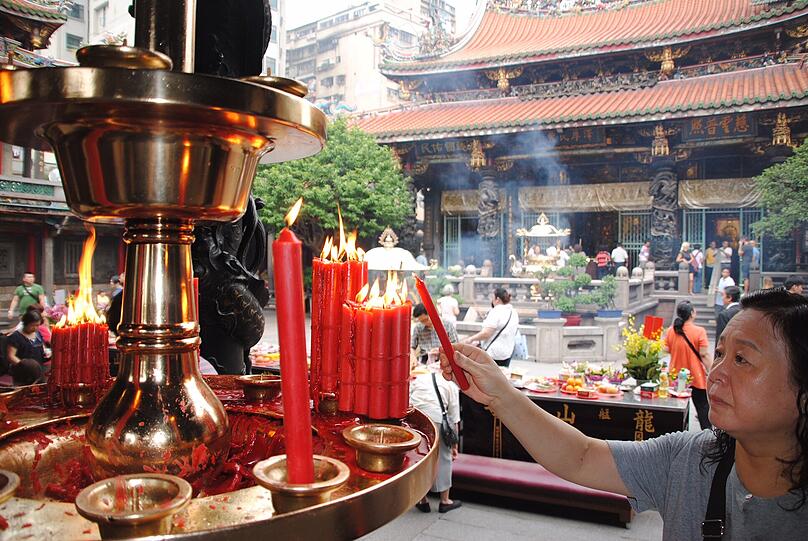 Durch das Verbrennen von Räucherstäbchen will diese Buddhistin im Mengjia-Longshan-Tempel von Taipeh die Geister der Luft und des Wassers gewogen stimmen.