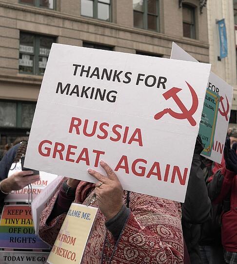 Eine Frau trägt bei Demonstration gegen den US-Präsidenten Donald Trump ein Schild mit der Aufschrift "THANKS FOR MAKING RUSSIA GREAT AGAIN".