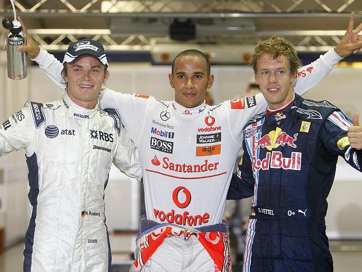 Nico Rosberg (l), Lewis Hamilton und Sebastian Vettel (r) jubeln nach der Qualifikation in Singapur.