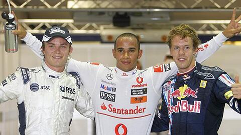 Nico Rosberg (l), Lewis Hamilton und Sebastian Vettel (r) jubeln nach der Qualifikation in Singapur.