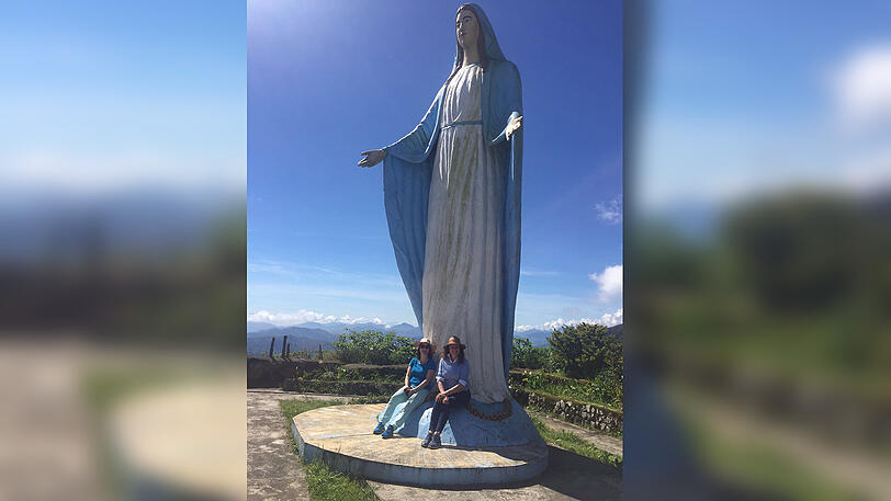 Uschi mit missio-Mitarbeiterin Ulrike vor einer XL-Christusfigur.