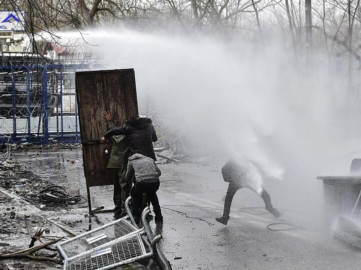 Migranten gehen an der griechisch-türkischen Grenze bei Zusammenstößen mit der griechischen Polizei in Deckung (Archiv).