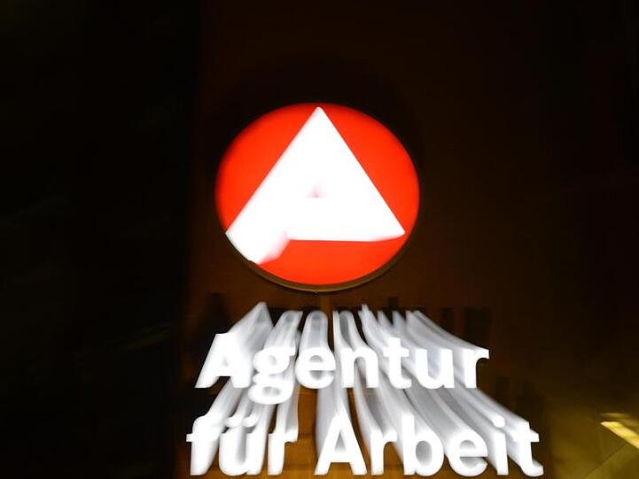 Eine Nachtaufnahme zeigt das Logo der Agentur für Arbeit. Foto: Patrick Seeger/dpa