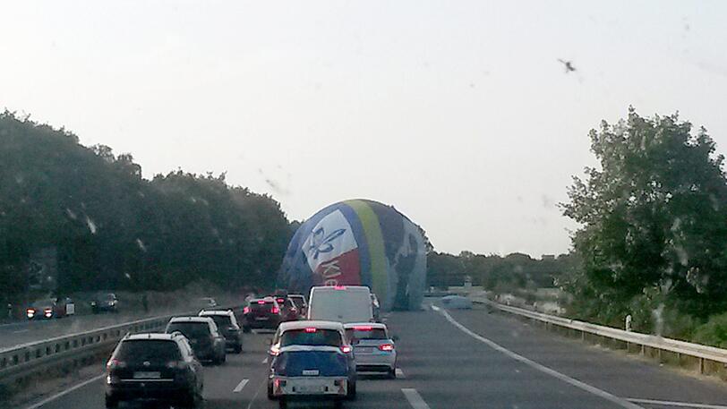 Viersen: Ein Heißluftballon landet auf Fahrbahn der A61 bei der Anschlussstelle Süchteln, während die Autos abstoppen.