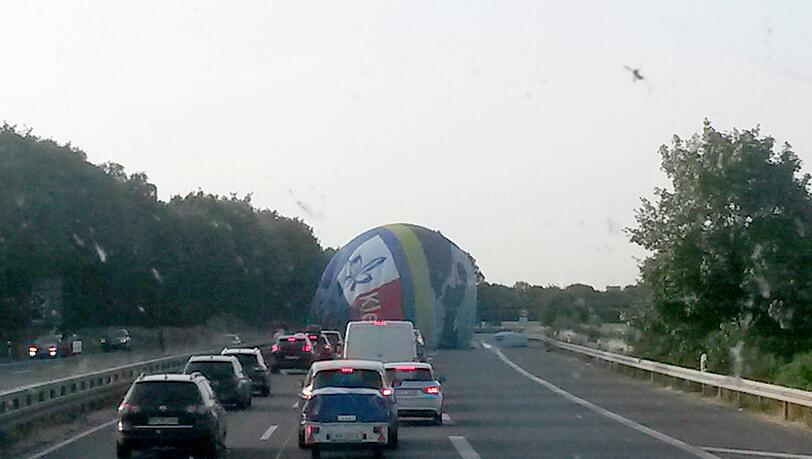 Viersen: Ein Heißluftballon landet auf Fahrbahn der A61 bei der Anschlussstelle Süchteln, während die Autos abstoppen. Viersen: Ein Heißluftballon landet auf Fahrbahn der A61 bei der Anschlussstelle Süchteln, während die Autos abstoppen.