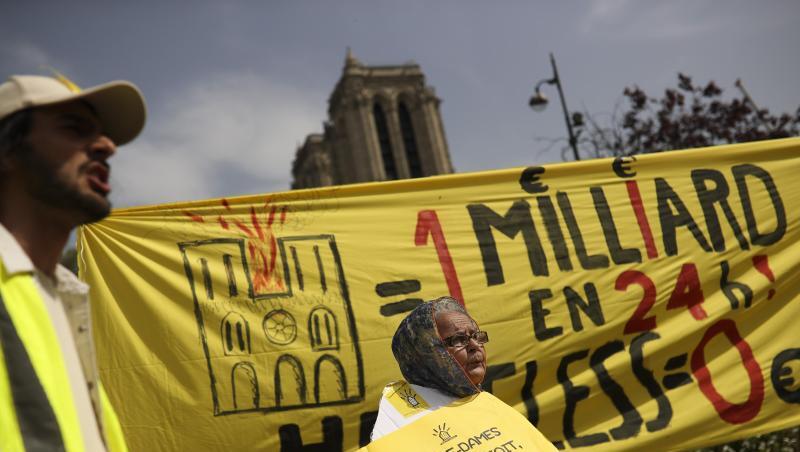 Bei einem Protest am Ostermontag vor der Notre-Dame Kathedrale werden Banner mit der Aufschrift auf Französisch: "Eine Milliarde in 24 Stunden! Obdachlos Null" und "Notre-Dame ist dachlos, wir auch!" gezeigt. Bei einem Protest am Ostermontag vor der Notre-Dame Kathedrale werden Banner mit der Aufschrift auf Französisch: "Eine Milliarde in 24 Stunden! Obdachlos Null" und "Notre-Dame ist dachlos, wir auch!" gezeigt.
