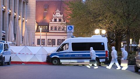 Kriminaltechniker gehen zum Tatfahrzeug.